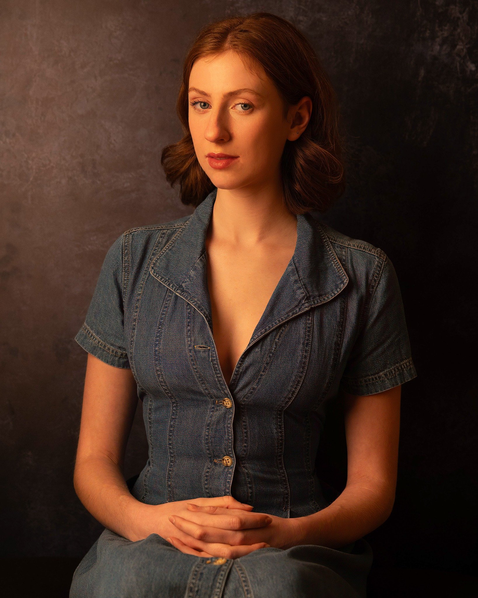 Young woman with brown hair and blue eyes in a denim shirt
